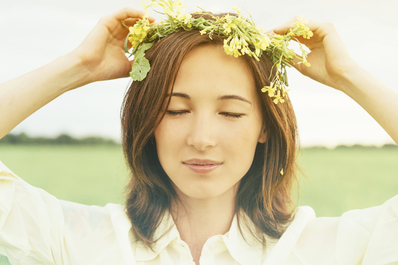 Beautiful woman with wreath of yellow wildflowers