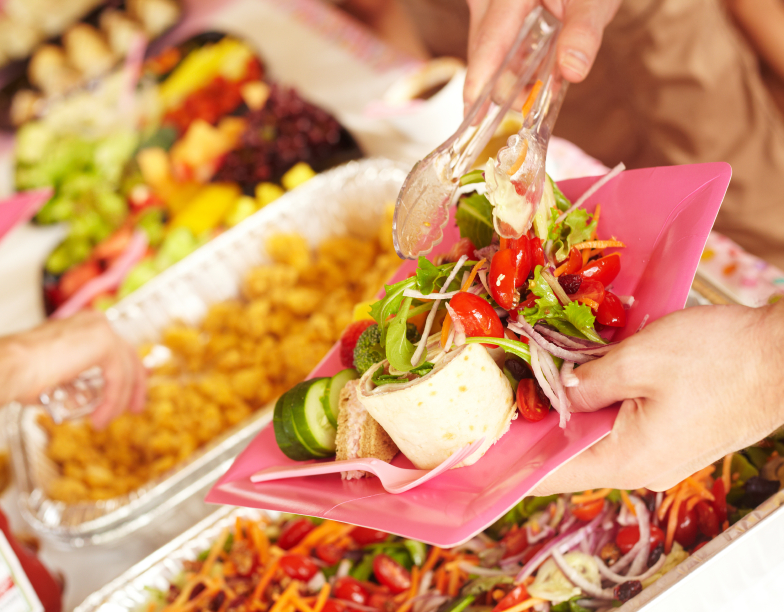 Woman Serving Vegetable Salad At Birthday Party